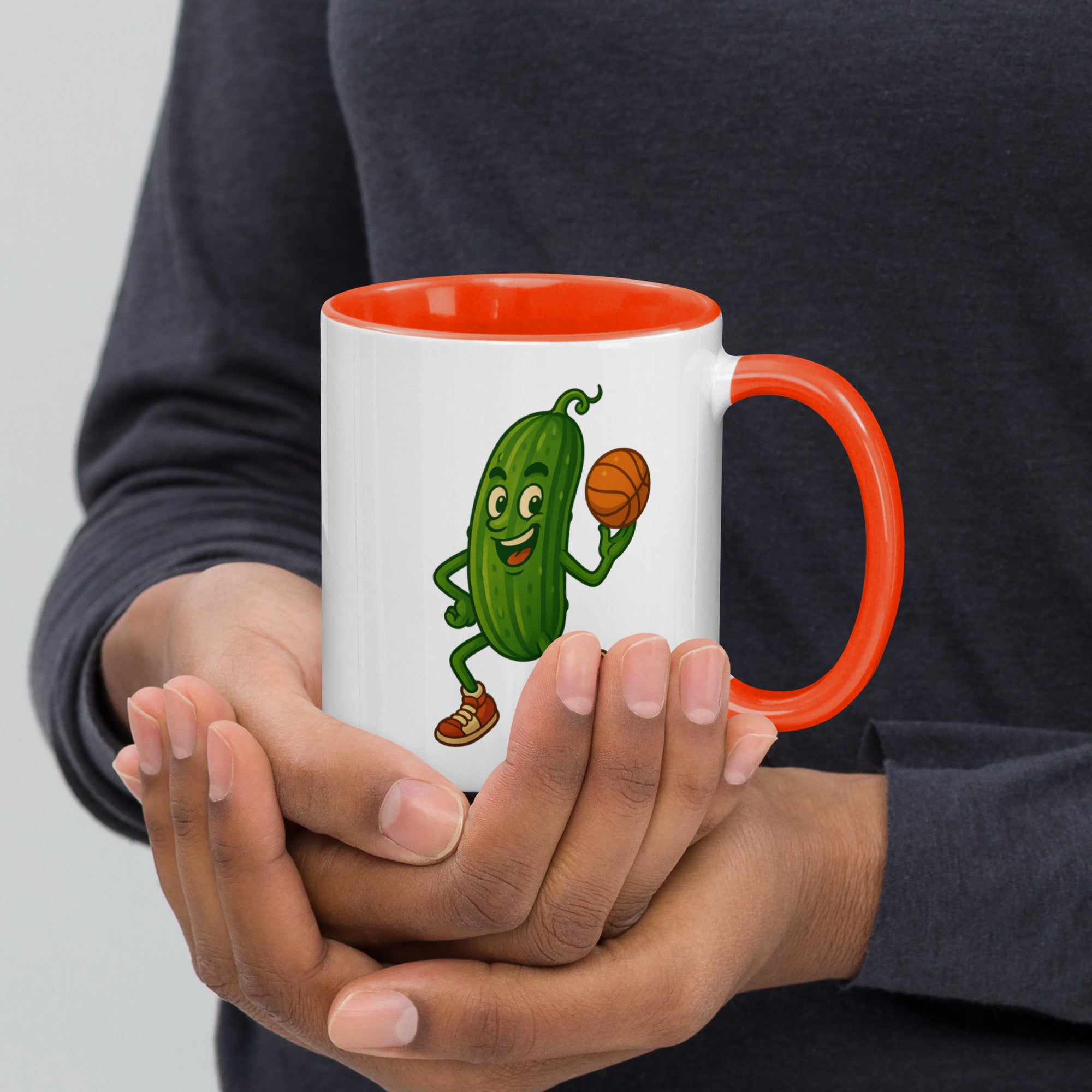 Fun ceramic mug with a cheerful pickle character playing basketball, featuring a vibrant orange interior.