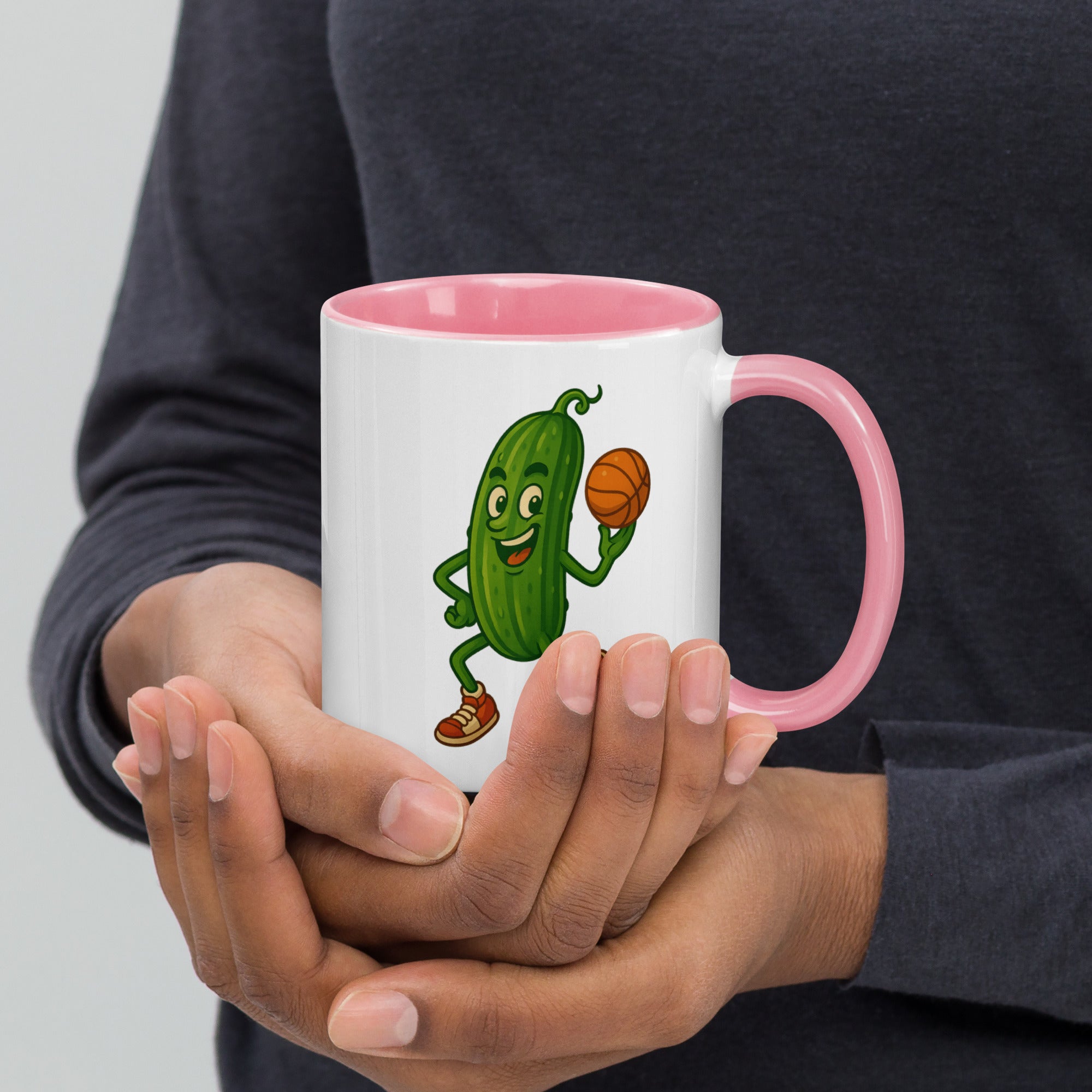 Colorful ceramic mug with a playful pickle character holding a basketball, featuring a pink interior.