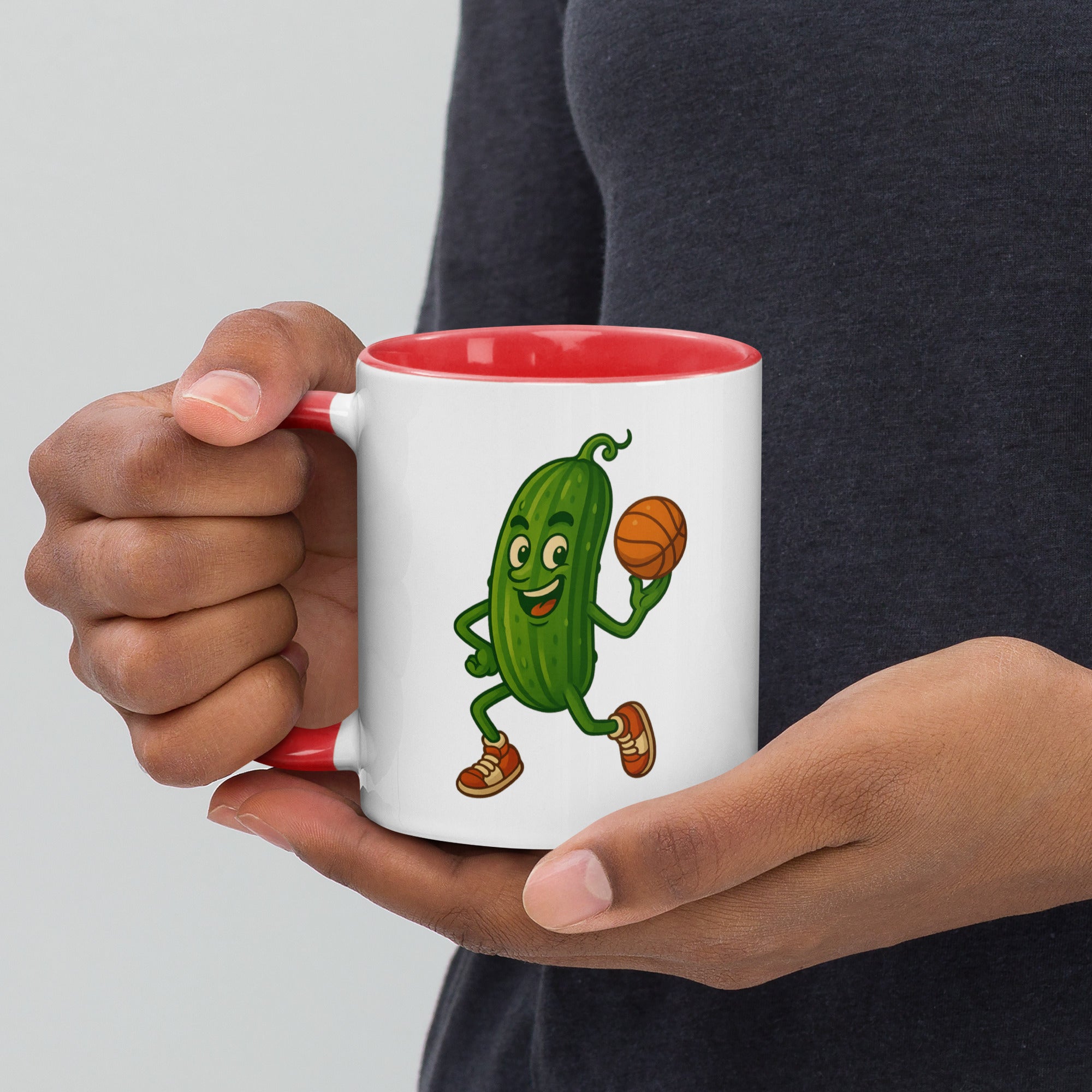 Colorful ceramic mug featuring a cartoon pickle playing basketball with a red interior, perfect for coffee or tea.